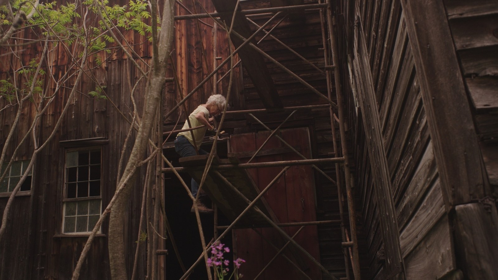 A family member climbs scaffolding beside the house