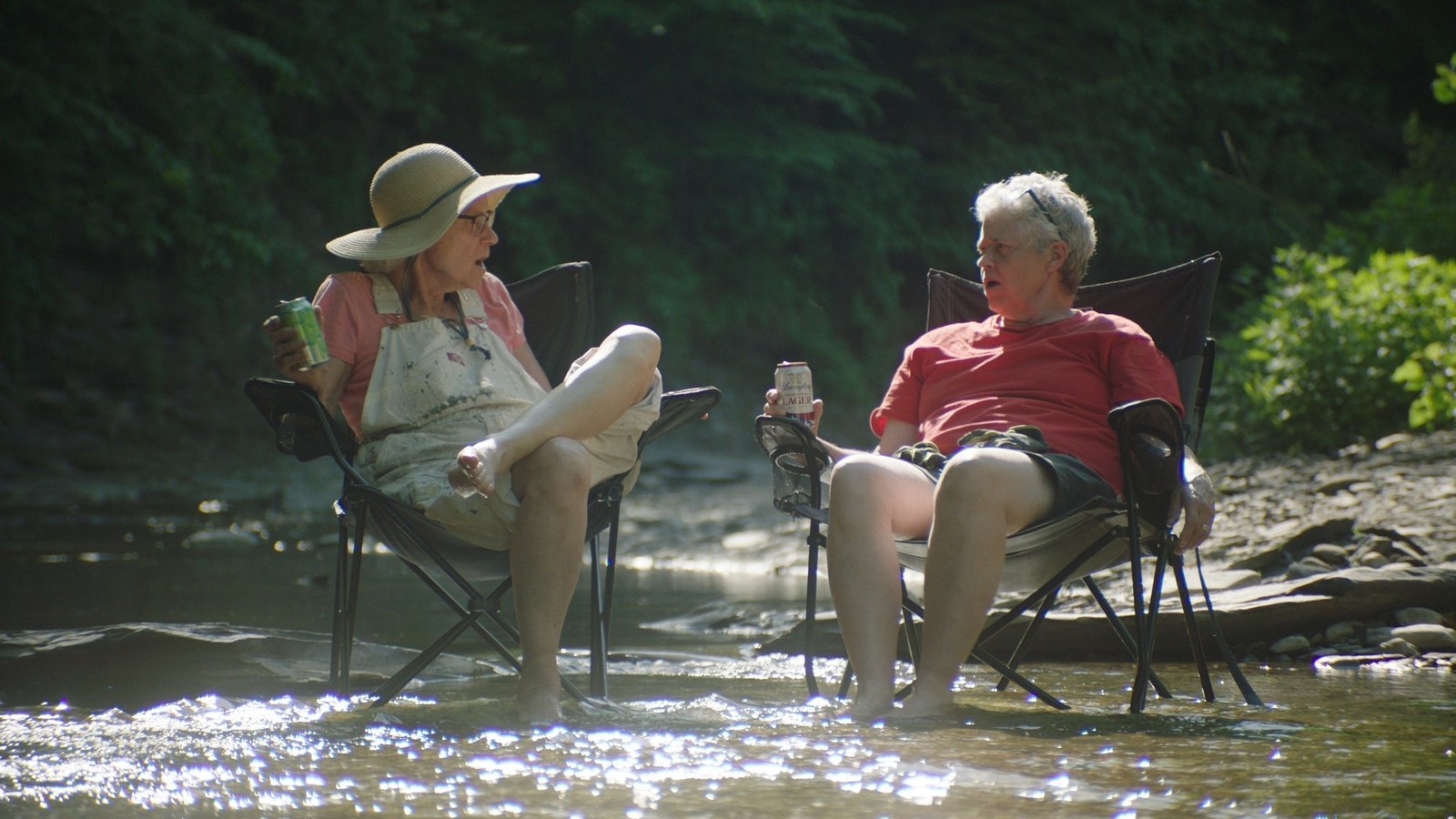 Two siblings talking while seated in a creek